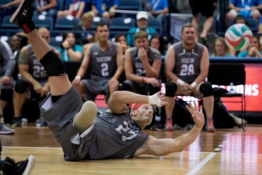A soldier dives for a ball against Team Army in the sitting volleyball bronze medal match.