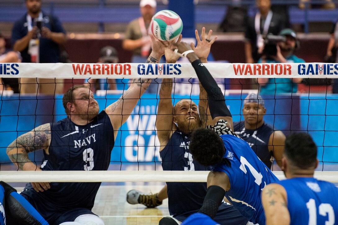 Sailors and airmen battle for the ball during the sitting volleyball gold medal match.