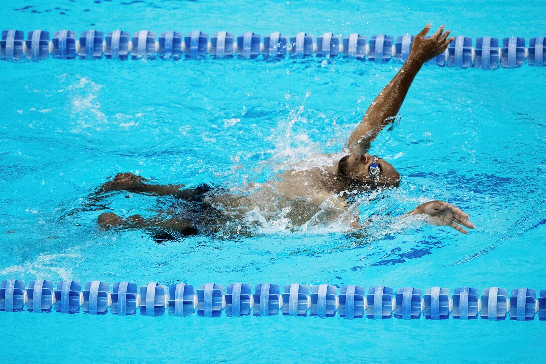 A soldier competes in the backstroke swimming event.