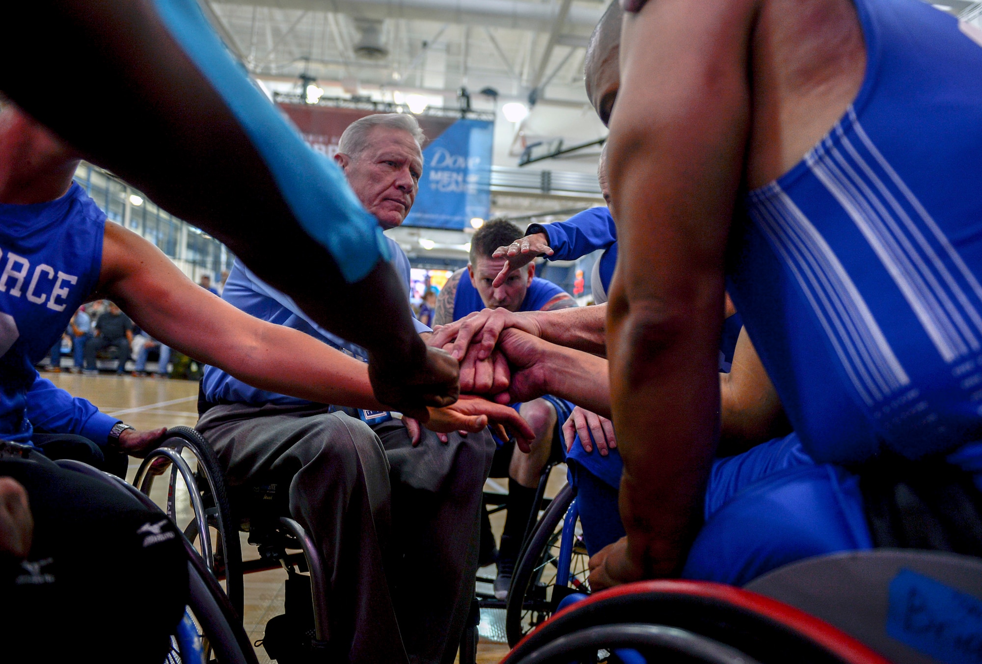 Team Air Force wheelchair basketball coach Mark Shepeherd gathers the team around before their game against Team Marine Corps during the Department of Defense Warrior Games at the U.S. Air Force Academy, Colorado Springs, Colo., June 3, 2018. Wheelchair basketball was developed by World War II U.S. veterans in 1945, and the sport was introduced on the global stage at the Rome 1960 Paralympic Games. Wheelchair basketball retains most major rules and scoring of basketball, but some rules have been modified with consideration for the wheelchair. (U.S. Air Force photo by Tech Sgt. Anthony Nelson Jr.)