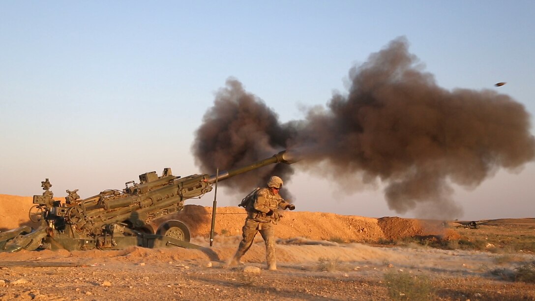 A person leans away from firing artillery.