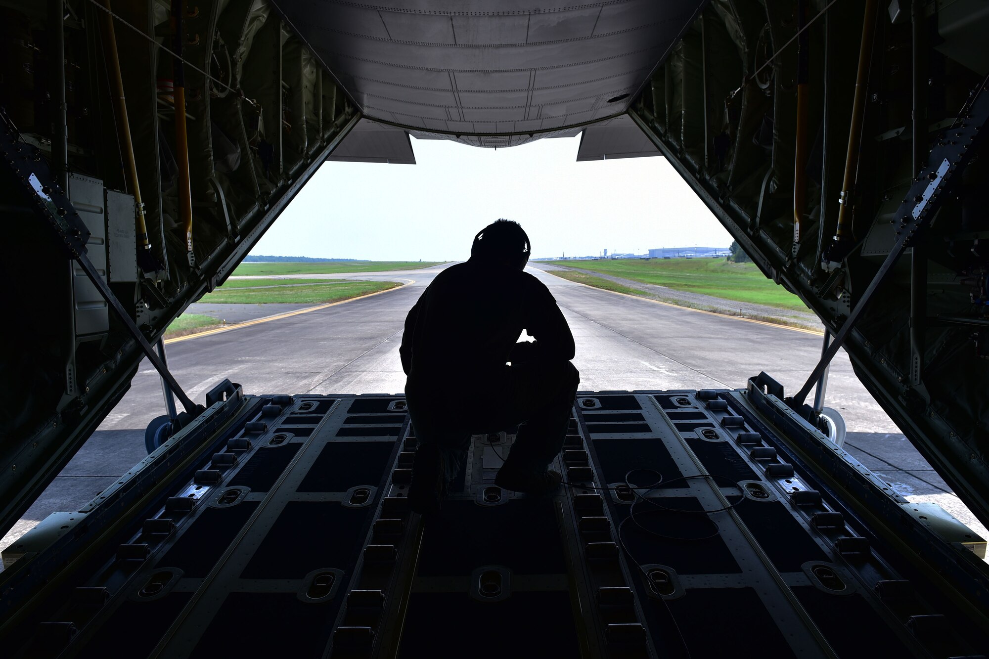 Man kneels on ramp of C-130J.
