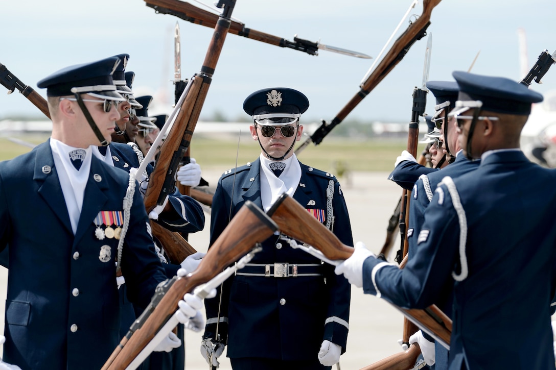 Airmen throw weapons during a choreographed routine.