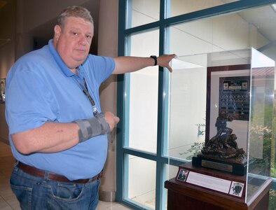 George Wunderlich, U.S. Army Medical Department Museum director, stands next to the new exhibit case holding The Command Sgt. Major Jack Clark Jr. Best Medic Award trophy and plaque displayed in the foyer of the museum. The display includes a bigger case made of dark oak wood, a photograph of Clark, the namesake for the award, and new labeling. The display is one of several exhibit upgrades and improvements, which started last year, that have been made at the museum.
