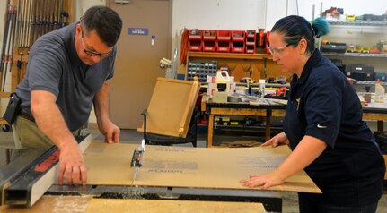 Christopher Goodrow (left) and Angelique Kelley (right), U.S. Army Medical Department Center of History and Heritage museum specialists, work on cutting and sizing a Lucite board for a new exhibit on Medal of Honor recipients who served in the U.S. Army Medical Department, or AMEDD, that will be put on display at the AMEDD Museum. Museum staff members were aiming to finish the new exhibit for public viewing by June 15.