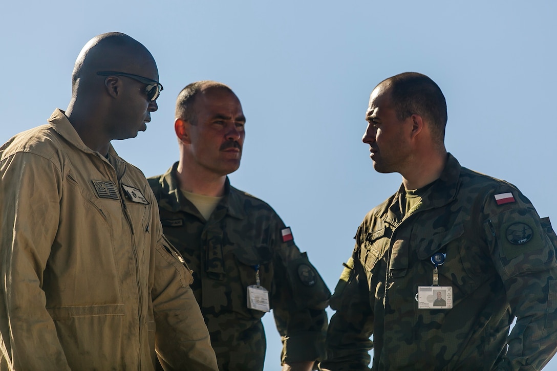 USTKA, Poland (June 8, 2018) U.S. Marine Corps Staff Sgt. R.V. Maggit, left, a section leader assigned to Tank Platoon, Fox Company, Battalion Landing Team, 2nd Battalion, 6th Marine Regiment, 26th Marine Expeditionary Unit, talks about the capabilities of an M1A1 Abrams tank with Polish Air Force members, father and son, after live-fire training during exercise Baltic Operations (BALTOPS) 2018 at Ustka, Poland, June 8. BALTOPS is the premier annual maritime-focused exercise in the Baltic region and one of the largest exercises in Northern Europe enhancing flexibility and interoperability among allied and partner nations. (Marine Corps photo by Staff Sgt. Dengrier M. Baez/Released)