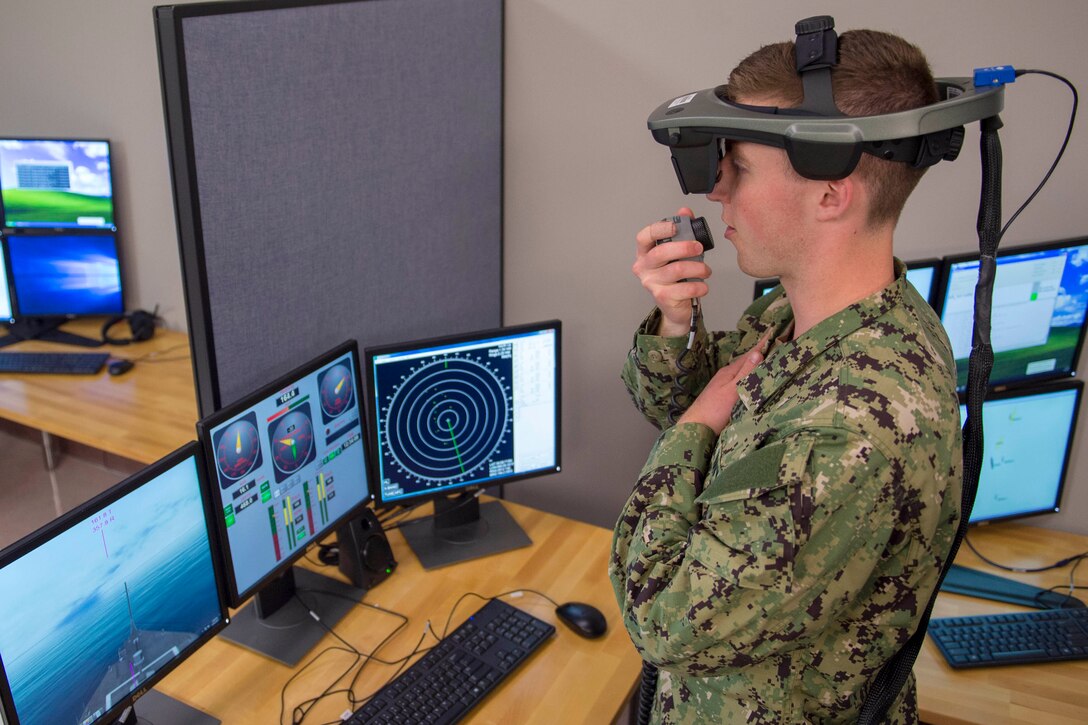 A sailor wears a virtual headset which he uses to navigate a virtual ship.