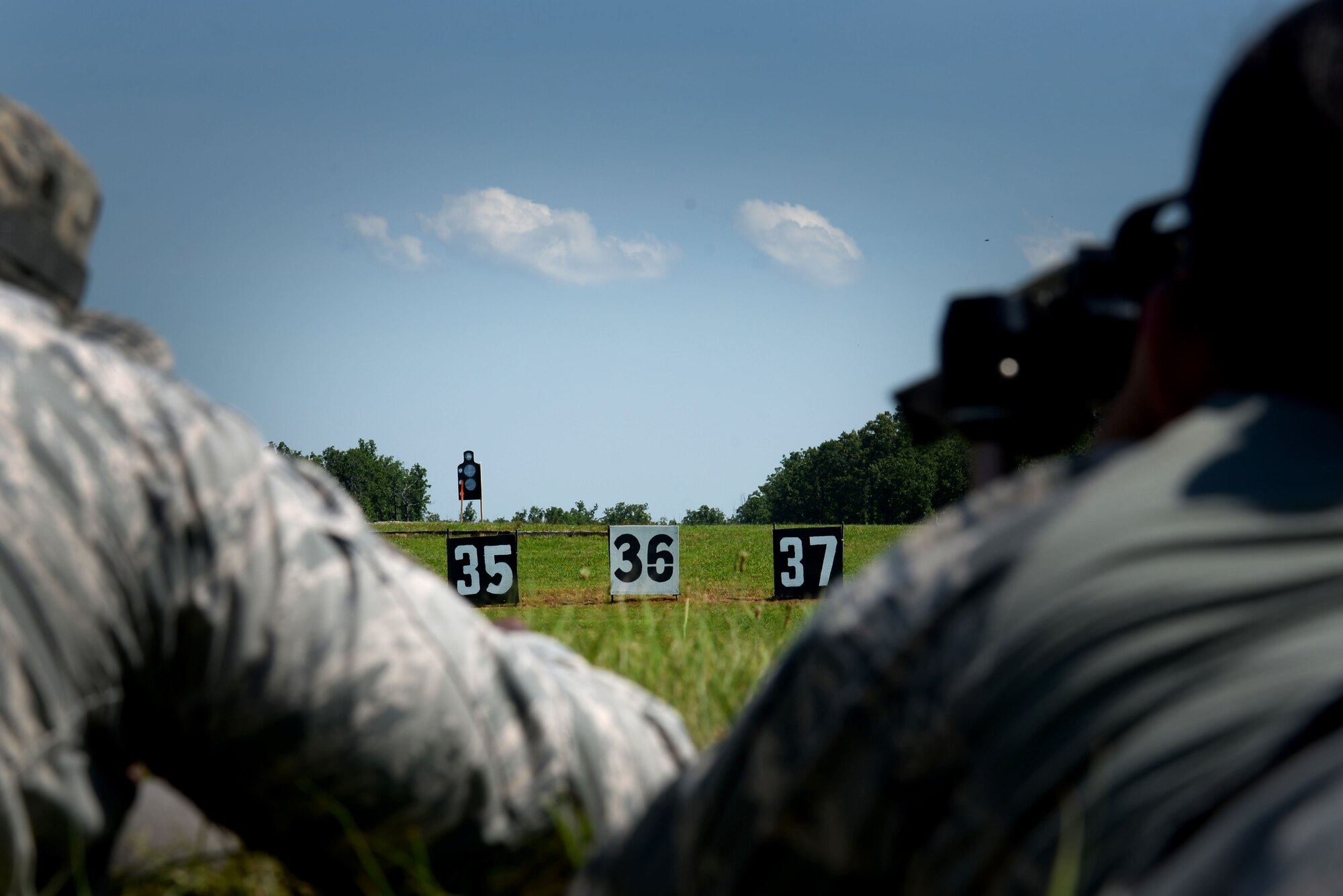 Two individuals wearing the Airman Battle Uniform look at a target.