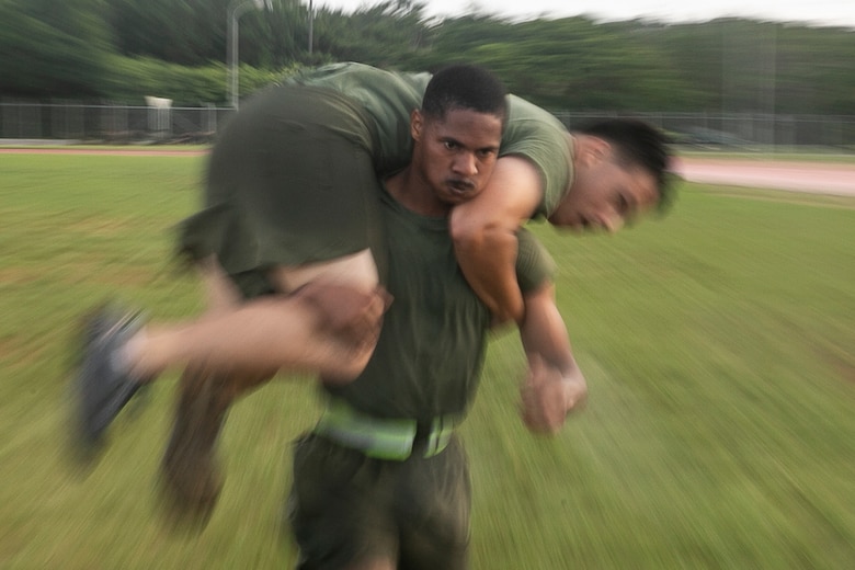 Sergeant Wesley Davison, a field radio operator with the 31st Marine Expeditionary Unit, fireman carries a fellow noncommissioned officer during a Force Fitness Instructor led High Intensity Tactical Training session at Camp Hansen, Okinawa, Japan, June 8, 2018.