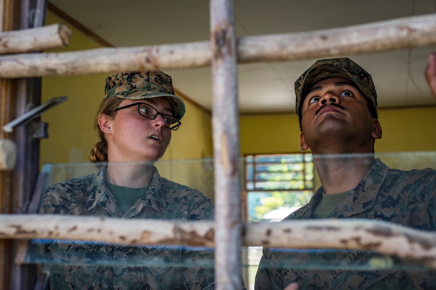 U.S. Marine Corps Cpls. Katherine Barden, left, and Lorenzo Cox, right, 7th Engineer Support Battalion combat engineers, Camp Pendleton, California, discuss their options for fixing a window during Pacific Angel 18-1, Suai, Timor-Leste, June 7, 2018.