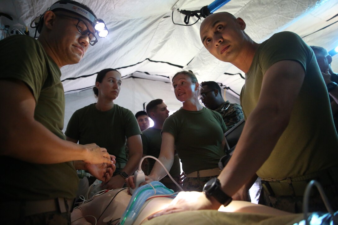 Navy field medical corpsmen with 3rd Medical Battalion, 3rd Marine Logistics Group provide emergency care to a dummy at Kin Blue on Okinawa, Japan, June 6, 2018.