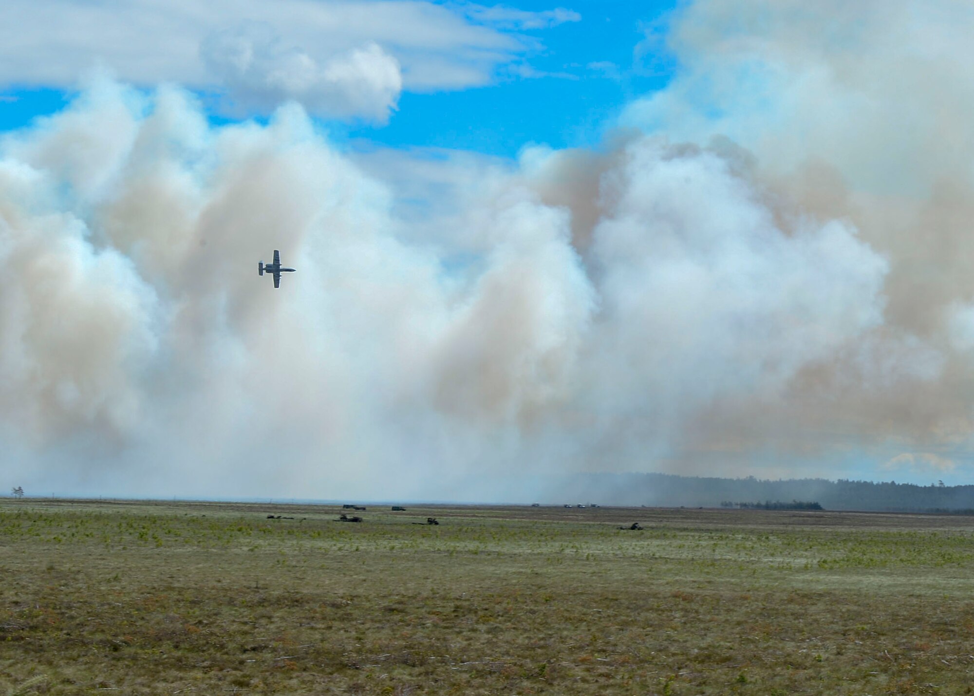 An A-10 Thunderbolt II flies past a plume of smoke during Saber Strike 18 at a field in Adazi, Latvia on June 5, 2018. A-10s deploy from the 127th Wing at Selfridge Air National Guard Base, Michigan, worked with Joint Terminal Attack Controllers during the exercise to improve synergy between the air and land components of warfighting. (U.S. Air Force photo by Staff Sgt. Jimmie D. Pike)