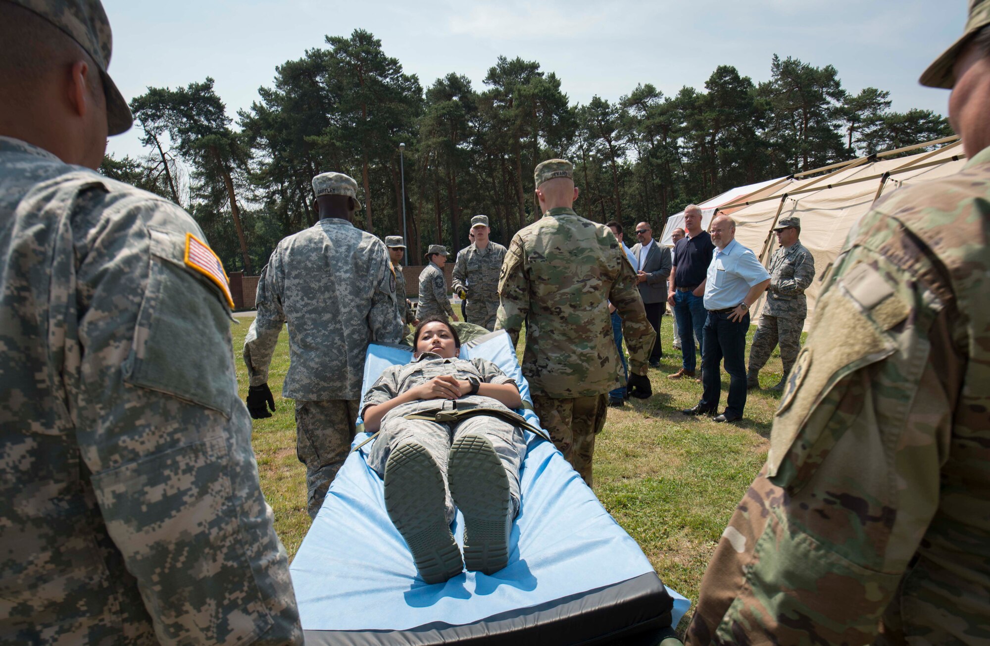 The 86th Medical Group, 345th Field Hospital, and 411th Hospital Center practice unloading a simulated patient from an ambulance during the 86th MDG's exercise Maroon Surge Community Outreach Day on Ramstein Air Base, Germany, June 7, 2018. Ramstein regularly welcomes community members to participate in tours and demonstrations to educate the public about Air Force capabilities, promote openness, and strengthen relations. (U.S. Air Force photo by Senior Airman Elizabeth Baker)