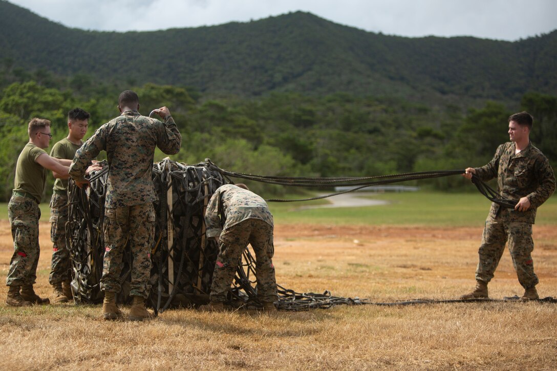 Landing support specialist Marines with Air Delivery Platoon, 3rd Transportation Support Battalion, 3rd Marine Logistics Group, participate in internal and external lift training June 6, 2018 at Landing Zone Dodo, Camp Hansen, Okinawa, Japan. Transporting cargo by aircraft provides a safe and efficient means for resupplying units in hostile environments or to deliver supplies during humanitarian crises. (U.S. Marine Corps photo by Lance Cpl. Zackary M. Walker)