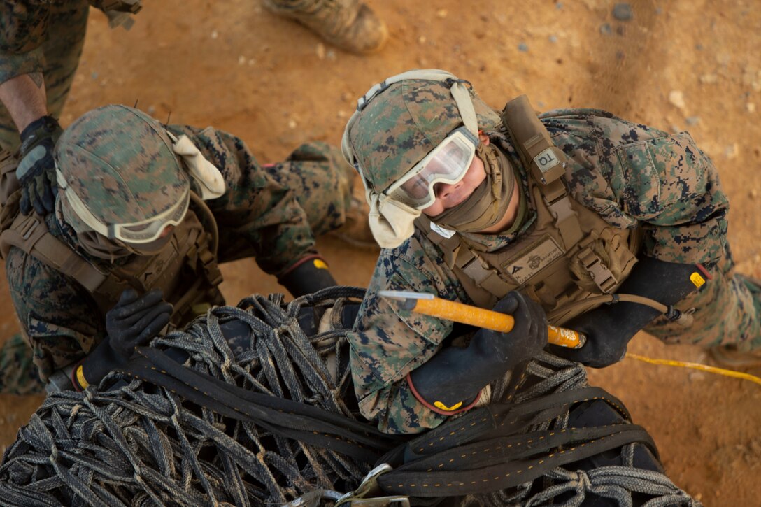 Landing support specialist Marines with Air Delivery Platoon, 3rd Transportation Support Battalion, 3rd Marine Logistics Group, hook a load of tires to an MV-22 Osprey during external lift training at Landing Zone Dodo, Camp Hansen, Okinawa, Japan, June 6, 2018. This training is designed to enhance the Marines’ techniques and procedures when securing cargo for external and internal lifts. (U.S. Marine Corps photo by Lance Cpl. Zackary M. Walker)