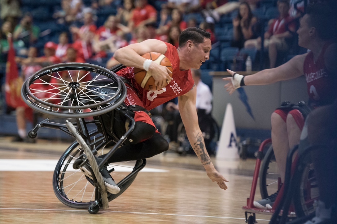 Marine Corps Staff Sgt. Jason Pacheco takes a spill as Navy defeats Marine Corps to win the wheelchair basketball bronze medal.