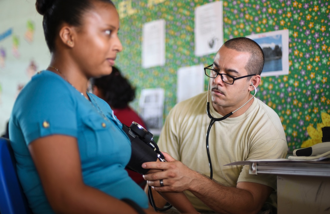 An Army nurse checks a patient’s blood pressure