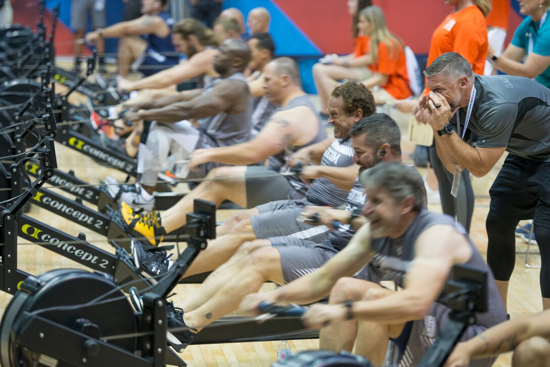 A sailor cheers for teammates during an indoor rowing competition.