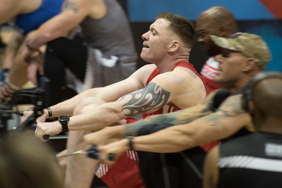 A Marine competes in an indoor rowing competition.