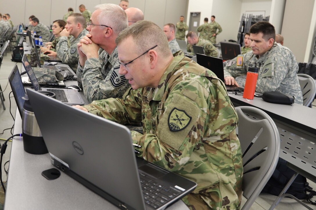 Soldiers and airmen work with computers during a cyber exercise.