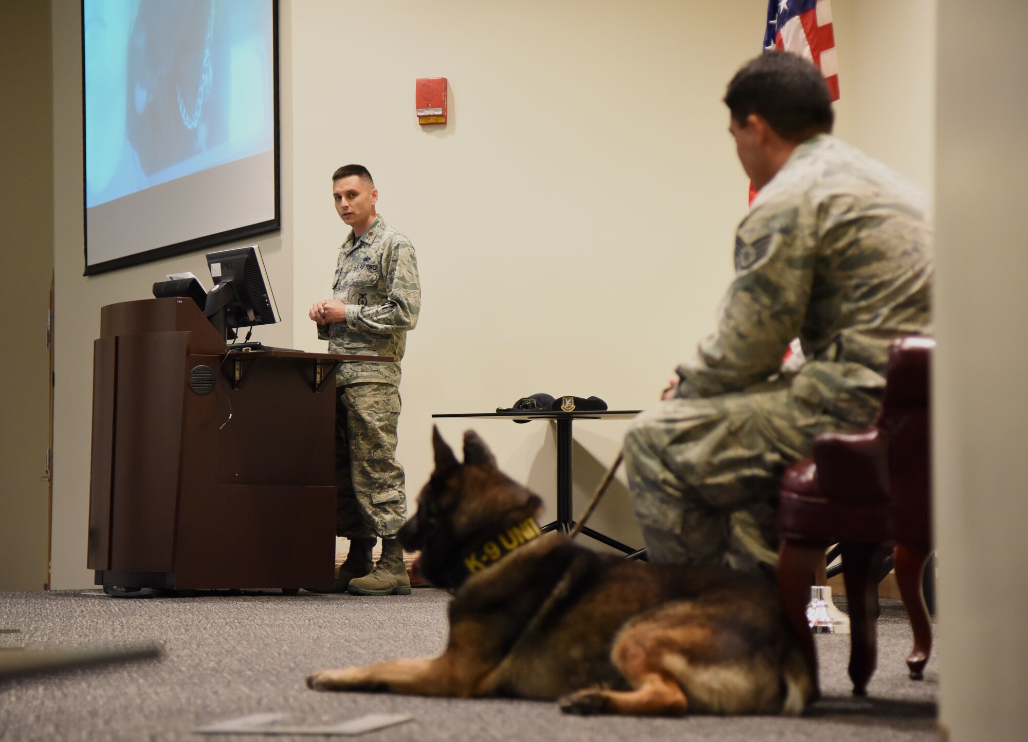U.S. Air Force Maj. Jonathon Murray, 81st Security Forces Squadron commander, delivers remarks about Staff Sgt. Matthew Ratchford, 81st SFS military working dog handler, and his MWD, Toki, during a retirement ceremony at the Roberts Consolidated Aircraft Maintenance Facility at Keesler Air Force Base, Mississippi, June 8, 2018. Toki retired with over 10 years of military service, which included four deployments that included the one deployment Ratchford and Toki served together. (U.S. Air Force photo by Kemberly Groue)
