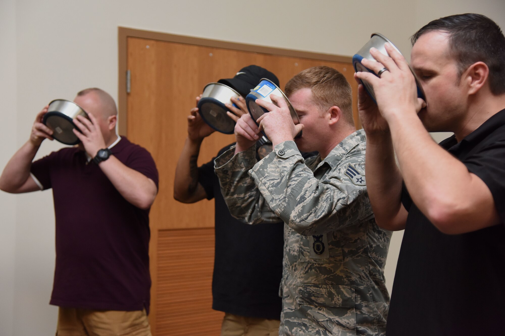 Members from the 81st Security Forces Squadron participate in a ceremonial toast to Toki, 81st SFS military working dog, for his retirement ceremony at the Roberts Consolidated Aircraft Maintenance Facility at Keesler Air Force Base, Mississippi, June 8, 2018. Toki retired with over 10 years of military service which included four deployments. (U.S. Air Force photo by Kemberly Groue)