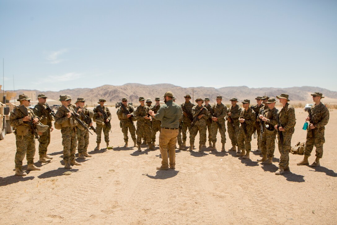 A counter-improvised explosive device instructor talks to Marines with Combat Logistics Battalion 25, Combat Logistics Regiment 45, 4th Marine Logistics Group, about identifying IEDs and convoy operation precautions, aboard Marine Corps Air Ground Combat Center Twentynine Palms, California, June 10, 2018. During Integrated Training Exercise 4-18, CLB-25 Marines took part in MOT to further their experience with crew-served weapons employment, IED immediate action drills and establishment of a Helicopter Landing Zone.