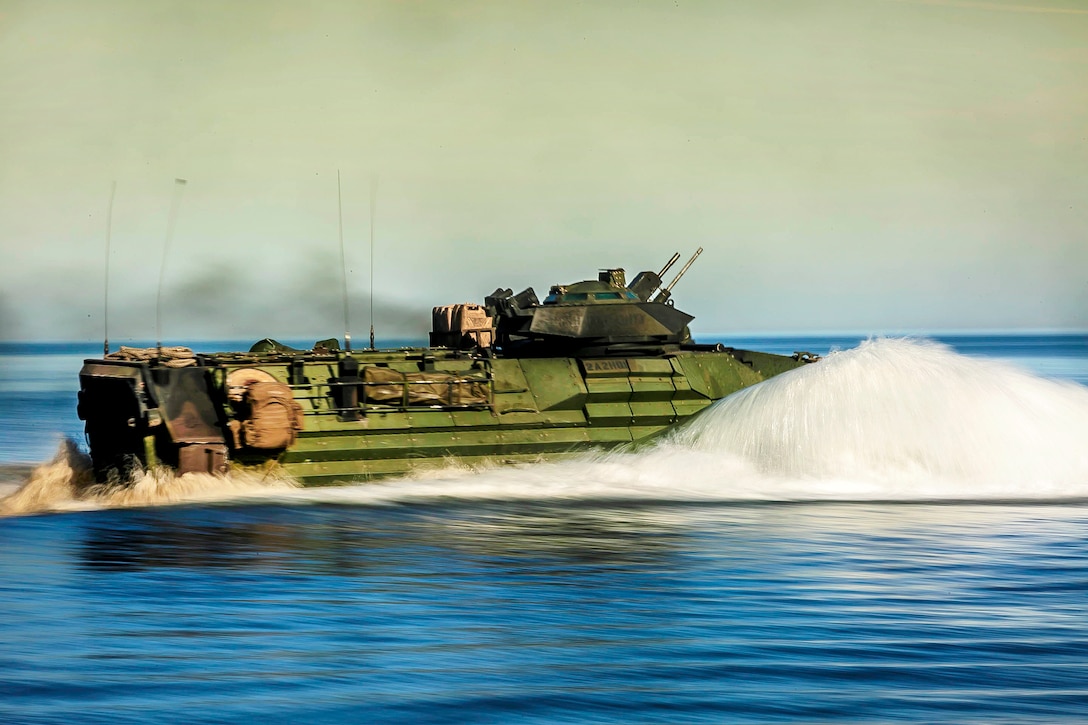 A Marine Corps AAV-P7/A1 amphibious assault vehicle enters the water.