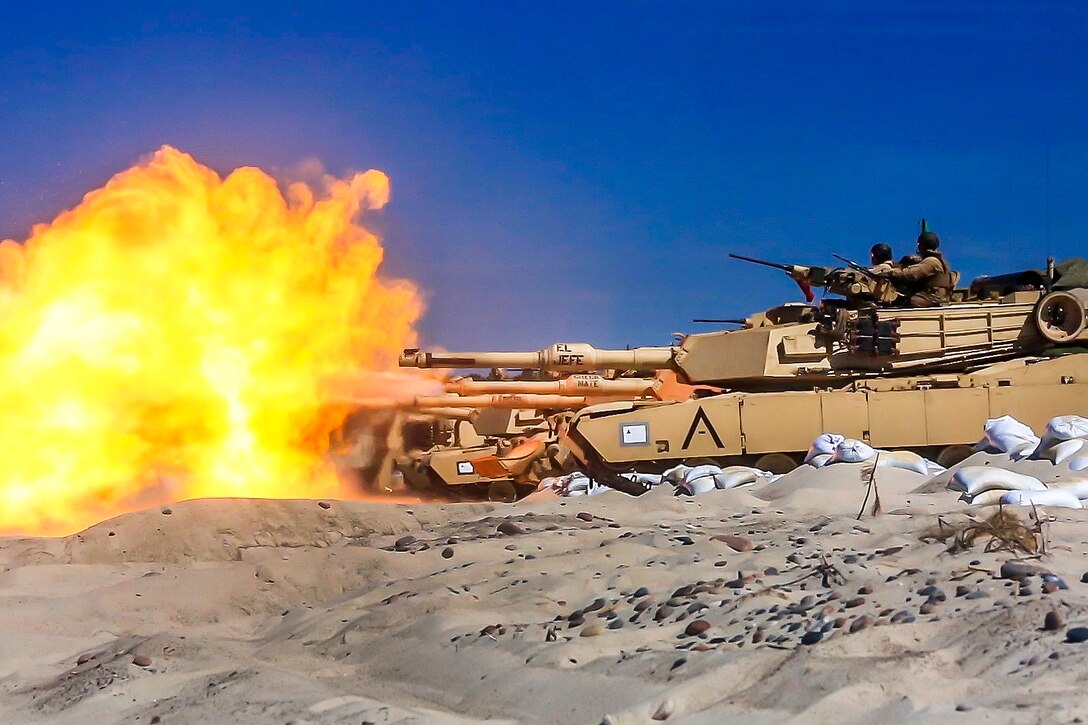 Marine Corps M1A1 Abrams tanks engage targets during a live-fire exercise.