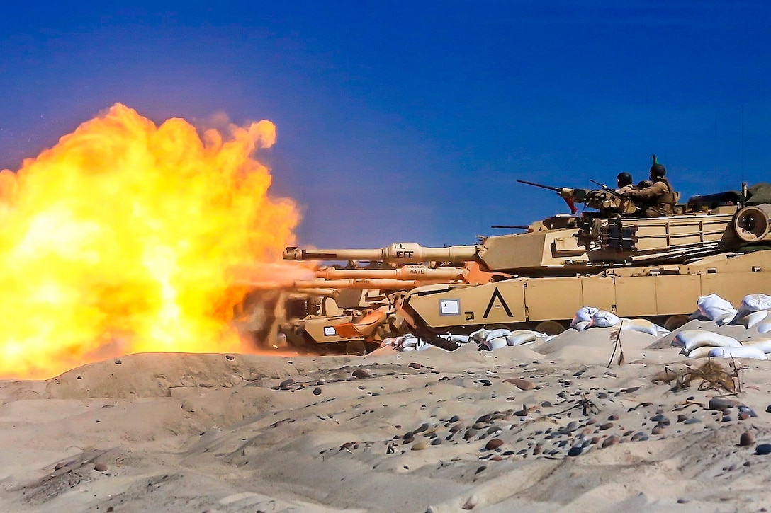 Marine Corps M1A1 Abrams tanks engage targets during a live-fire exercise.