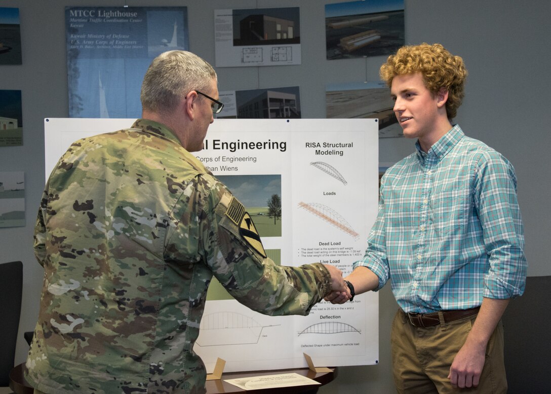 Nathan Weins, High School Intern with MED September through December 2017, is congratulated by Middle East District Commander Col. Stephen Bales, following his end of semester presentation about a bridge he designed.