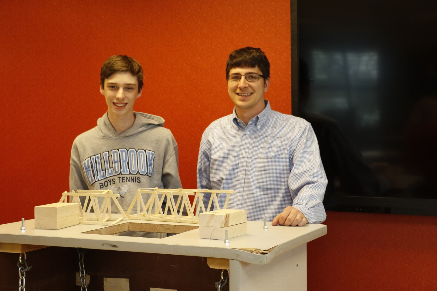 Intern Josh Dalton with High School Intern Program and Structural Engineer Nathan Fox following Dalton's end of semester bridge break test. Fox assists interns in exploring engineering disciplines and building their self-confidence.