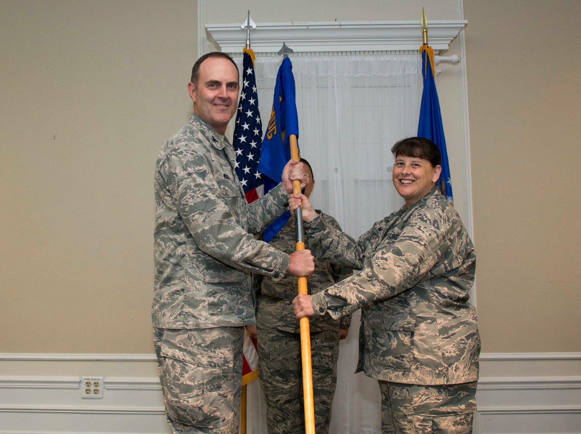 U.S. Air Force Col. Brian Wyrick, 20th Medical Group (MDG) commander, left, passes the 20th Medical Support Squadron (MDSS) guidon to Lt. Col. Melissa Meister, 20th MDSS commander, at Shaw Air Force Base, S.C., June 12, 2018.