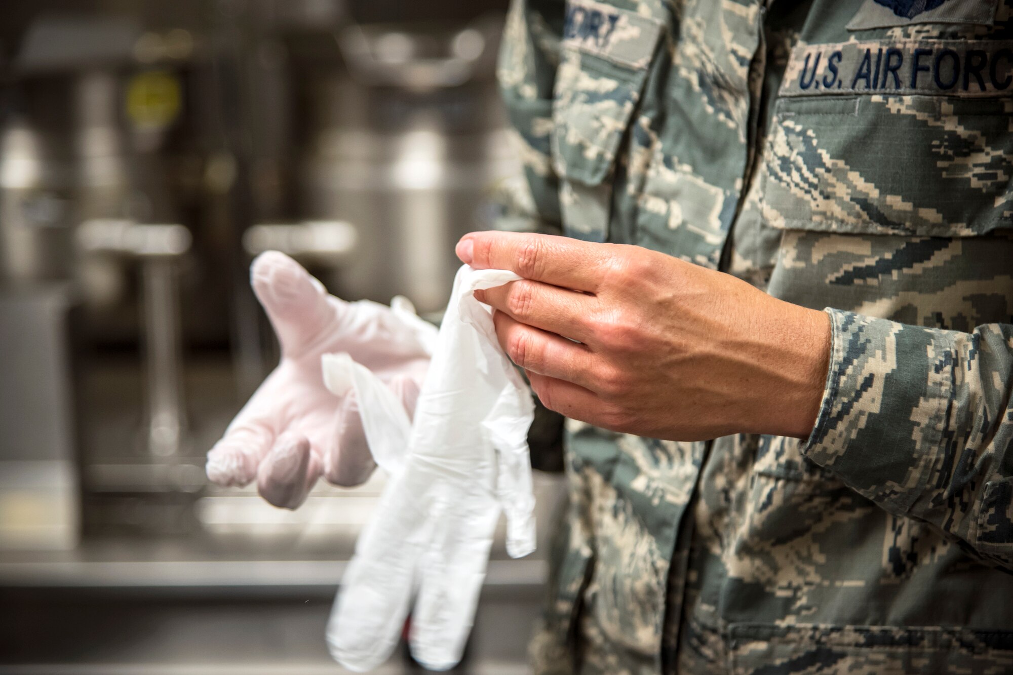 Col. Jennifer Short, 23d Wing (WG) commander, puts on gloves during an immersion tour, June 11, 2018, at Moody Air Force Base, Ga. Short and Chief Master Sgt James Allen, 23d WG command chief, toured the Georgia Pines Dining Facility and the Information Learning Center to gain a better understanding of their overall mission, capabilities and comprehensive duties. (U.S. Air Force photo by Airman 1st Class Eugene Oliver)