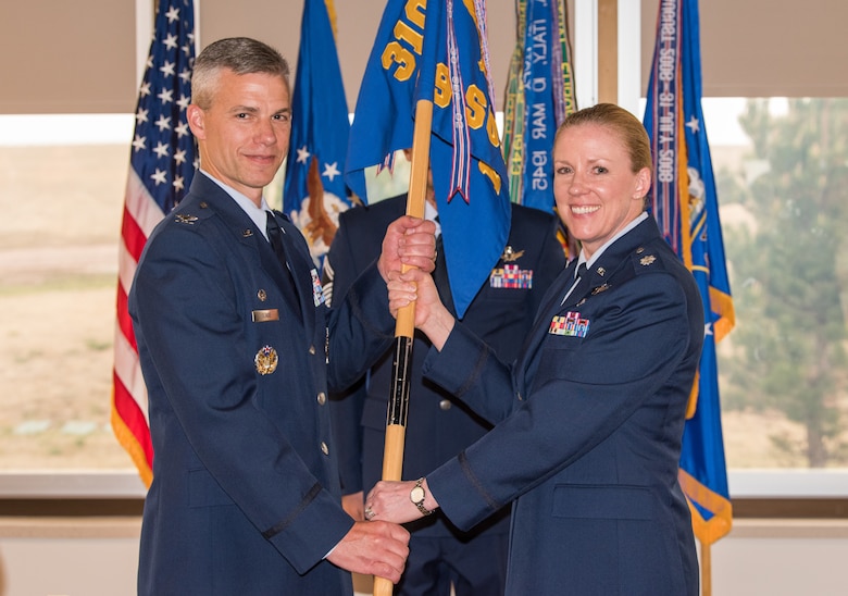 Col. Stephen Slade, 310th Operations Group commander, receives the 19th Space Operations Squadron guidon from Lt. Col. Karen Slocum as she relinquishes command of the squadron, June 3, 2018.