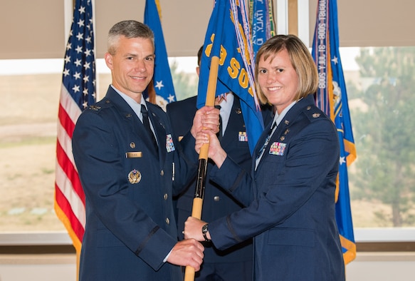 Col. Stephen Slade, 310th Operations Group commander, passes the 19th Space Operations Squadron guidon to Lt. Col. Beth Stargardt as she takes command of 19 SOPS, June 3, 2018.