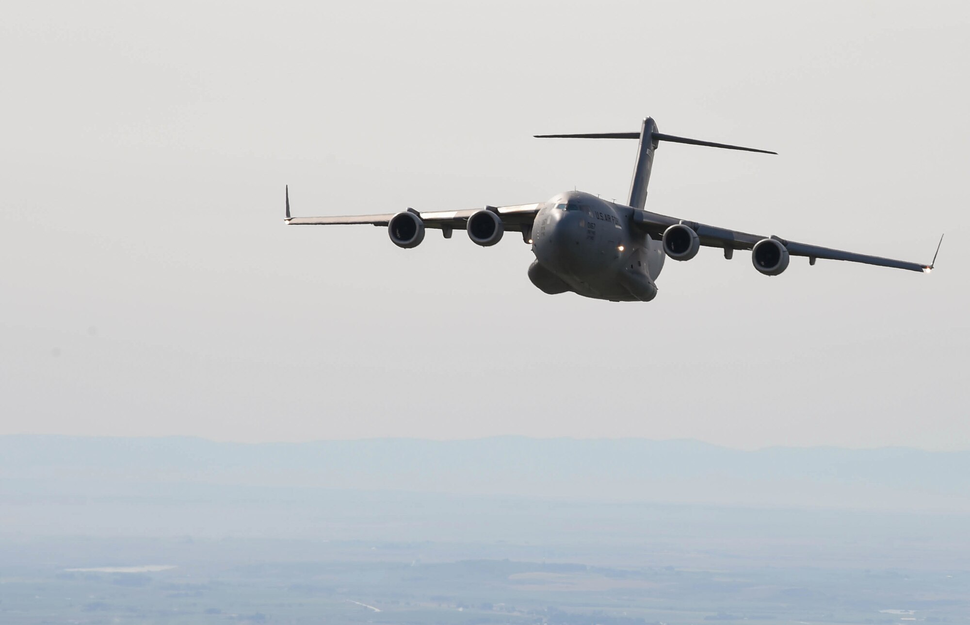A C-17 Globemaster III flies during Exercise Rainier War to perform container delivery system bundle airdrops near Moses Lake, Wash., June 6, 2018. During the exercise, 20 C-17s from the U.S. and Australia performed actual container delivery system (CDS) and heavy equipment airdrops at the Rainier Drop Zone near Moses Lake, and simulated improved CDS, CDS and high altitude low opening personnel airdrops throughout the western United States. (U.S. Air Force photo by Senior Airman Tryphena Mayhugh)