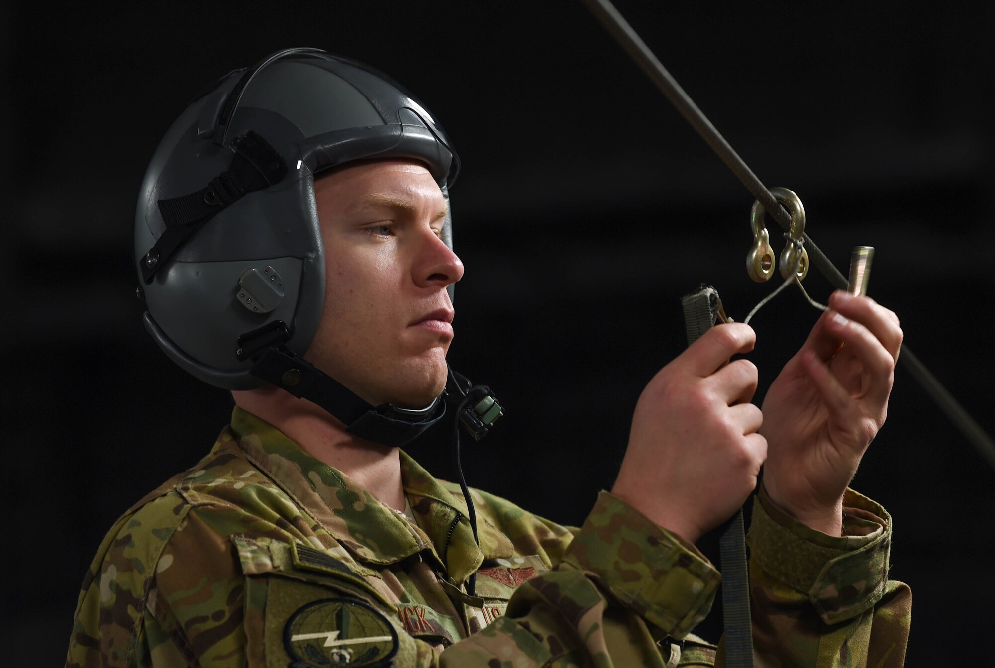 Staff Sgt. Matthew Duck, 7th Airlift Squadron loadmaster, unhooks a parachute cover after dropping two bundles out of a C-17 Globemaster III onto the Rainier Drop Zone during Exercise Rainier War near Moses Lake, Wash., June 6, 2018. During the exercise, 20 C-17s from the U.S. and Australia performed actual container delivery system (CDS) and heavy equipment airdrops at the Rainier Drop Zone near Moses Lake, and simulated improved CDS, CDS and high altitude low opening personnel airdrops throughout the western United States. (U.S. Air Force photo by Senior Airman Tryphena Mayhugh)