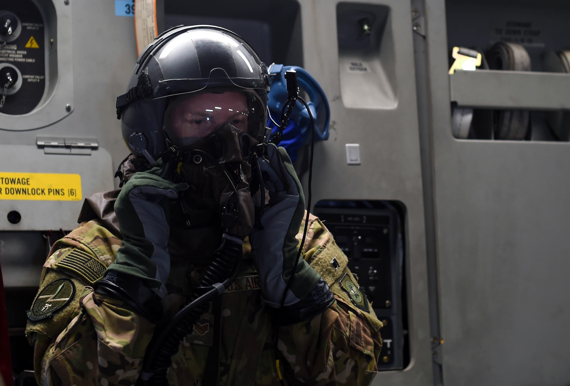 Staff Sgt. Matthew Duck, 7th Airlift Squadron loadmaster, tests the functionality of his aircrew eye and respiratory protection system while flying in a C-17 Globemaster III near Moses Lake, Wash., June 6, 2018. Duck was participating in Exercise Rainier War, which provided insights on how to better execute a tactical scenario for possible future conflicts. (U.S. Air Force photo by Senior Airman Tryphena Mayhugh)