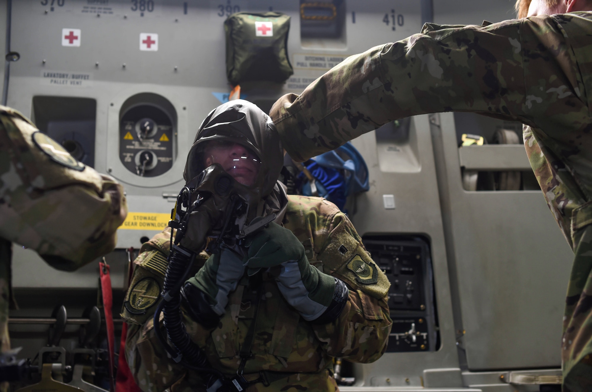 Staff Sgt. Matthew Duck, 7th Airlift Squadron loadmaster, removes an aircrew eye and respiratory protection system while flying in a C-17 Globemaster III during Exercise Rainier War near Moses Lake, Wash., June 6, 2018. The purpose of exercise was to highlight the C-17’s capabilities to perform the Air Force’s core competencies of rapid global mobility and precision engagement. (U.S. Air Force photo by Senior Airman Tryphena Mayhugh)