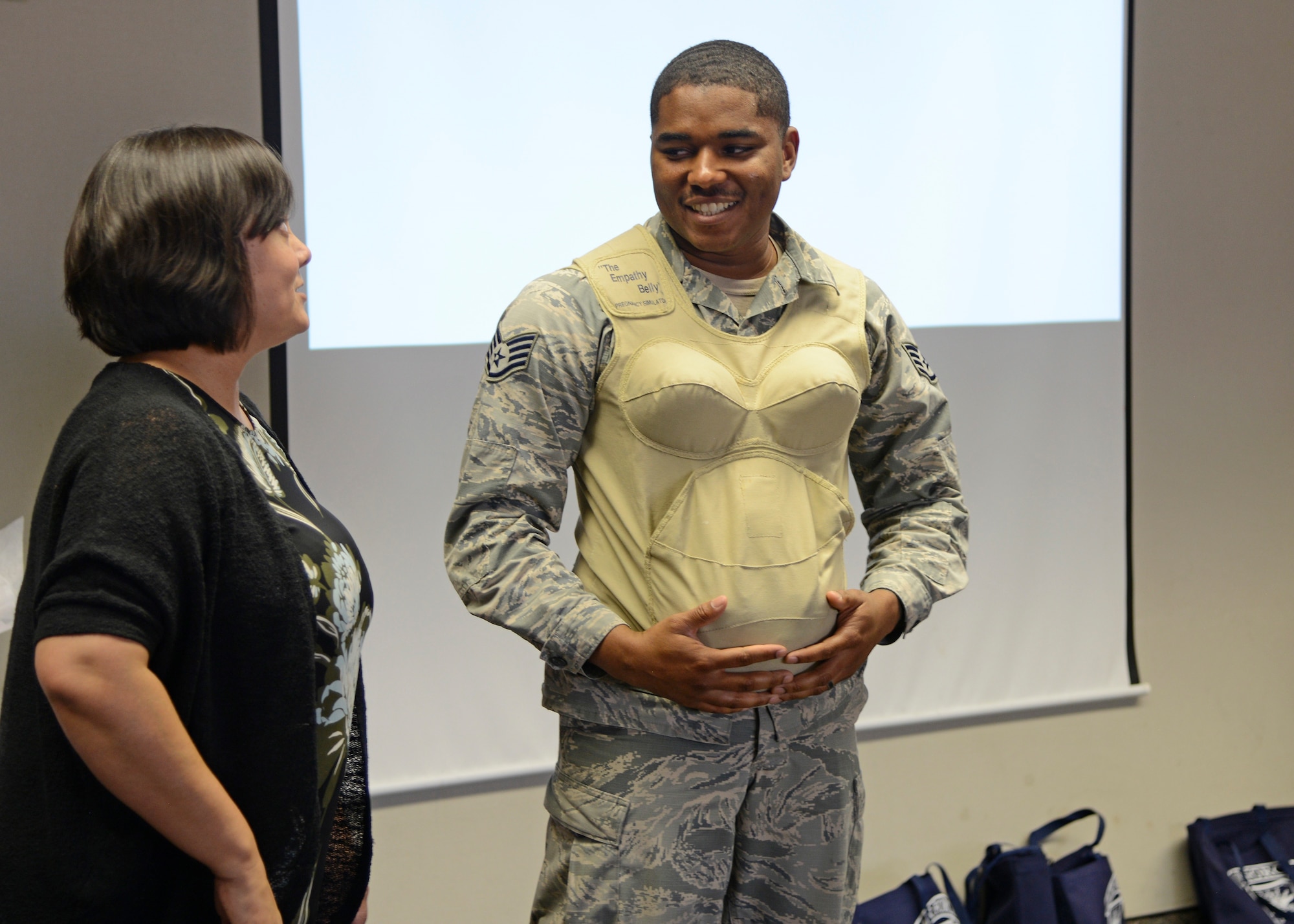 Arlene Johnson, Family Advocacy outreach manager tries the empathy belly on a future father, Staff Sgt. Gregory Bolden, 31st Test and Evaluation Squadron, to simulate the weight that is carried during pregnancy. (U.S. Air Force photo by Laura Motes)
