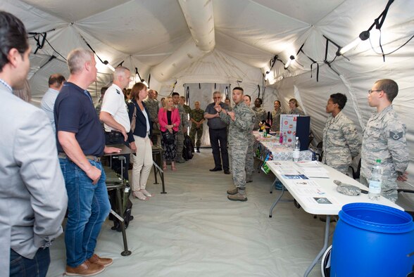 U.S. Air Force Capt. Ricardo Aldahondo, middle, 86th Medical Support Squadron Resource Management Flight commander, gives a tour of an Air Force Expeditionary Medical System (EMEDS) to host nation distinguished visitors during the 86th Medical Group's exercise Maroon Surge Community Outreach Day on Ramstein Air Base, Germany, June 7, 2018. An EMEDS is a deployable medical unit, like a tent-hospital, that is fully equipped and has rooms that can be added and removed. Ramstein welcomed visitors to tour the facilities to educate the public about Air Force capabilities, promote openness, and strengthen relations. (U.S. Air Force photo by Senior Airman Elizabeth Baker)