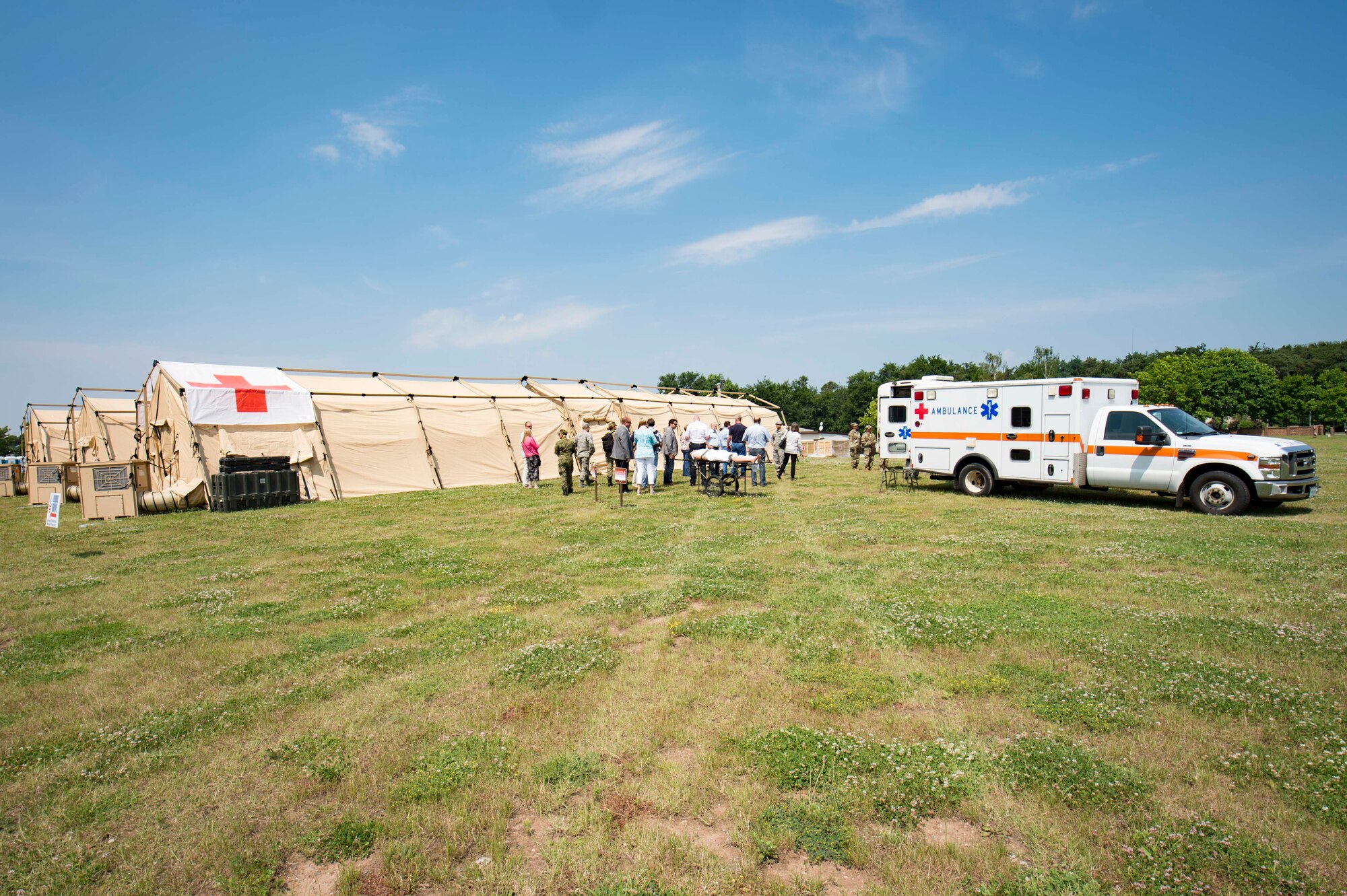 Host nation distinguished visitors watch a simulated ambulance loading and unloading during the 86th Medical Group's exercise Maroon Surge Community Outreach Day on Ramstein Air Base, Germany, June 7, 2018. The visitors also received a tour of an Expeditionary Medical System, from the diagnosis room to the surgery room. The 86th MDG designed Community Outreach Day to educate the public on their life-saving capabilities and also invite them to participate in saving a life by donating blood and bone marrow. (U.S. Air Force photo by Senior Airman Elizabeth Baker)