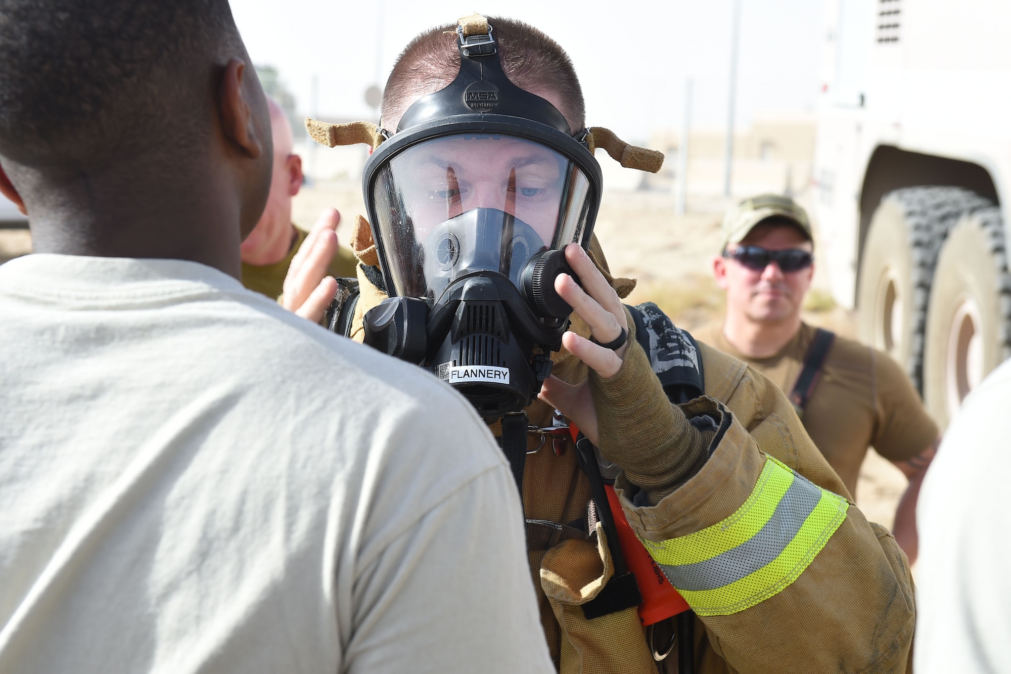 Man in firefighter suit puts on mask