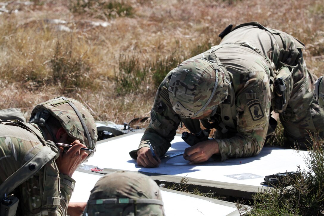 Soldiers plot coordinates for a land navigation exercise.