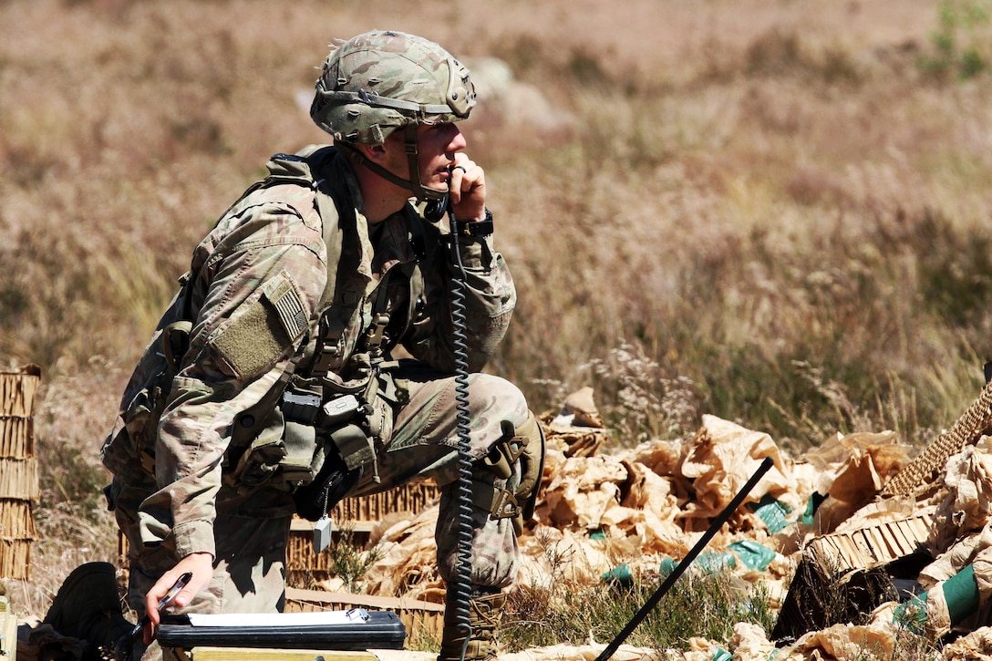 A soldier relays information to his fellow soldiers during a training event.