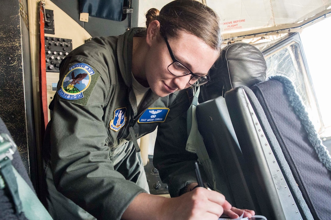 An airman checks data in an airplane's cockpit.
