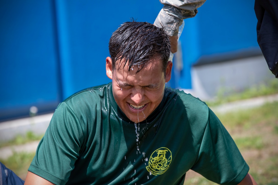 An airman is drenched with cold water after he finishes a four-person relay race.
