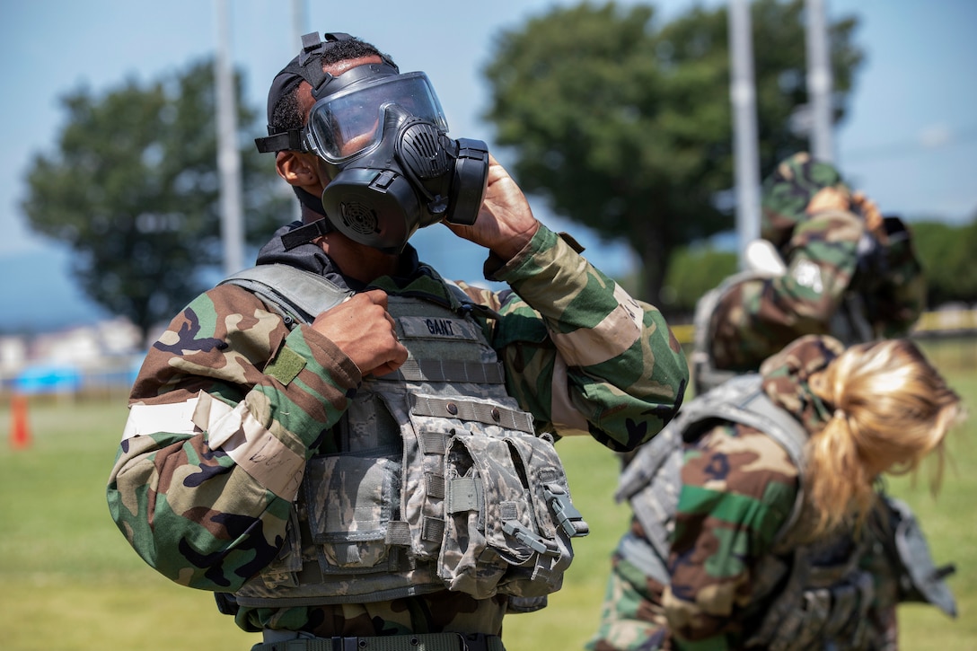 An airman wear mission-oriented protective posture gear participates in an Ability to Survive and Operate Rodeo.