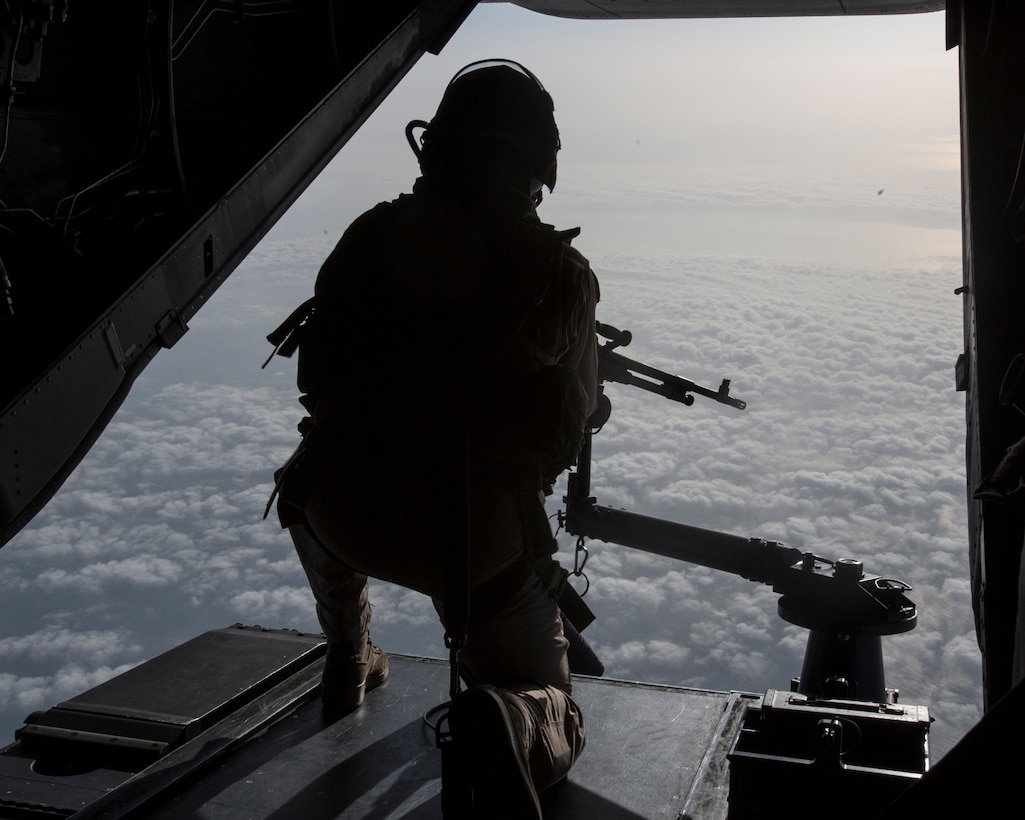 A U.S. Marine crew member for an MV-22 Osprey with Special Purpose Marine Air-Ground Task Force-Crisis Response-Africa posts security with a mounted weapon during a flight to Africa on May 31, 2018. SPMAGTF-CR-AF deployed to conduct crisis-response and theater-security operations in Europe and North Africa. (U.S. Marine Corps photo by Staff Sgt. Britni M. Garcia Green/Released)